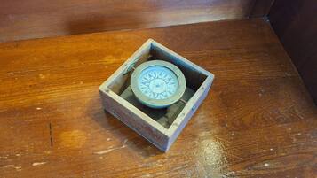 A compass in a wooden box on a wooden floor.