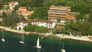 Une ville côtière avec des bâtiments le long du front de mer, des bateaux sur l’eau et une vue dégagée sur la mer.