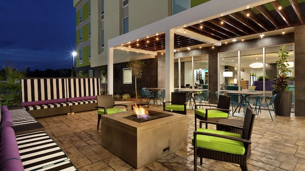 An outdoor patio area with a fire pit, seating, and a covered dining area. - Home2 Suites by Hilton West Monroe (West Monroe)