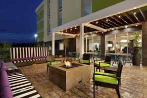 An outdoor patio area with a fire pit, seating, and a covered dining area. - Home2 Suites by Hilton West Monroe (West Monroe)