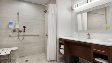 A modern bathroom with a shower, a vanity with a mirror, and a toilet.