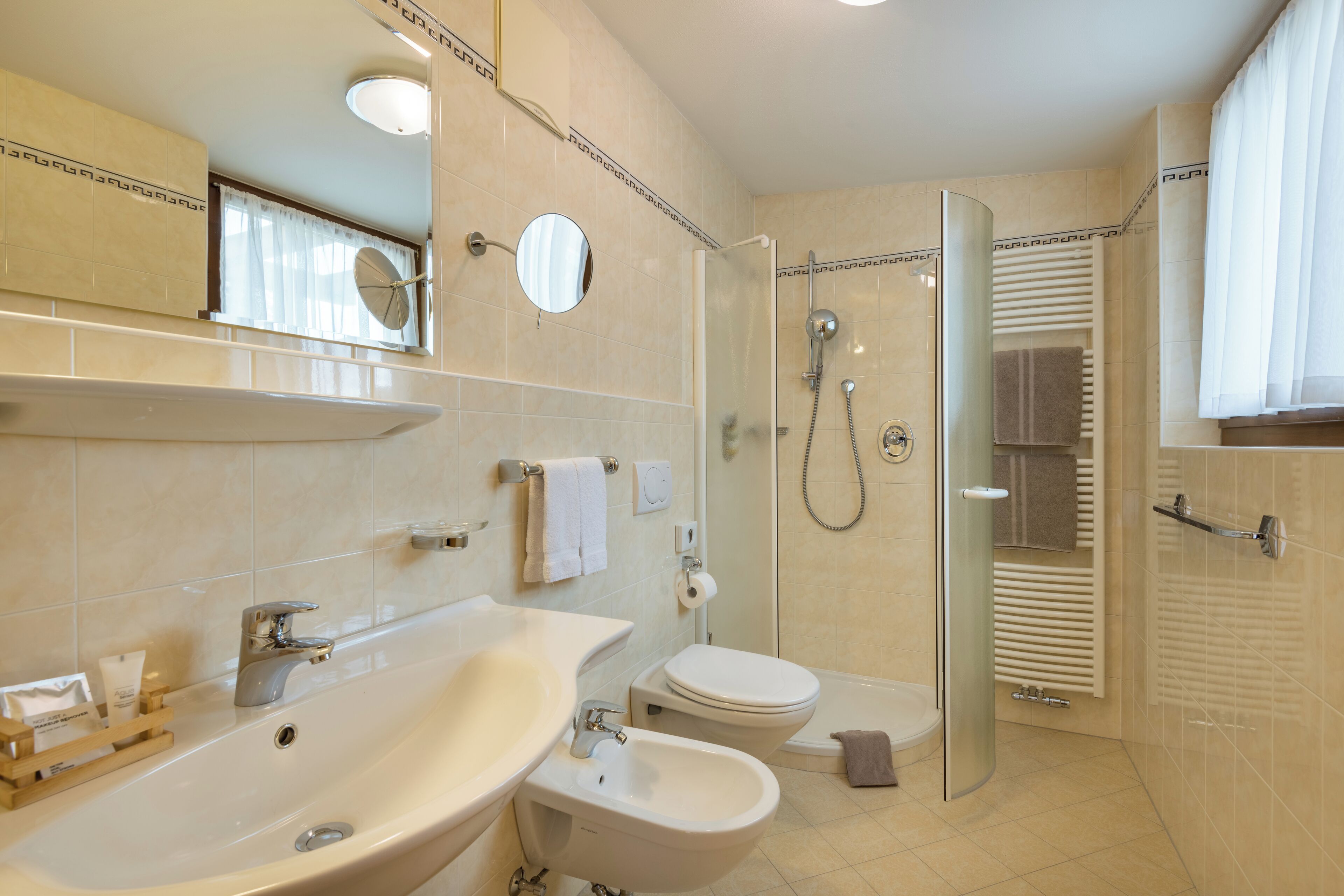 Un bagno moderno con lavandino, bidet, WC e doccia.