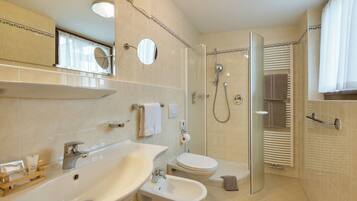 Un bagno moderno con lavandino, bidet, WC e doccia.
