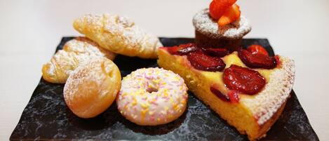 A variety of pastries on a black slate plate.
