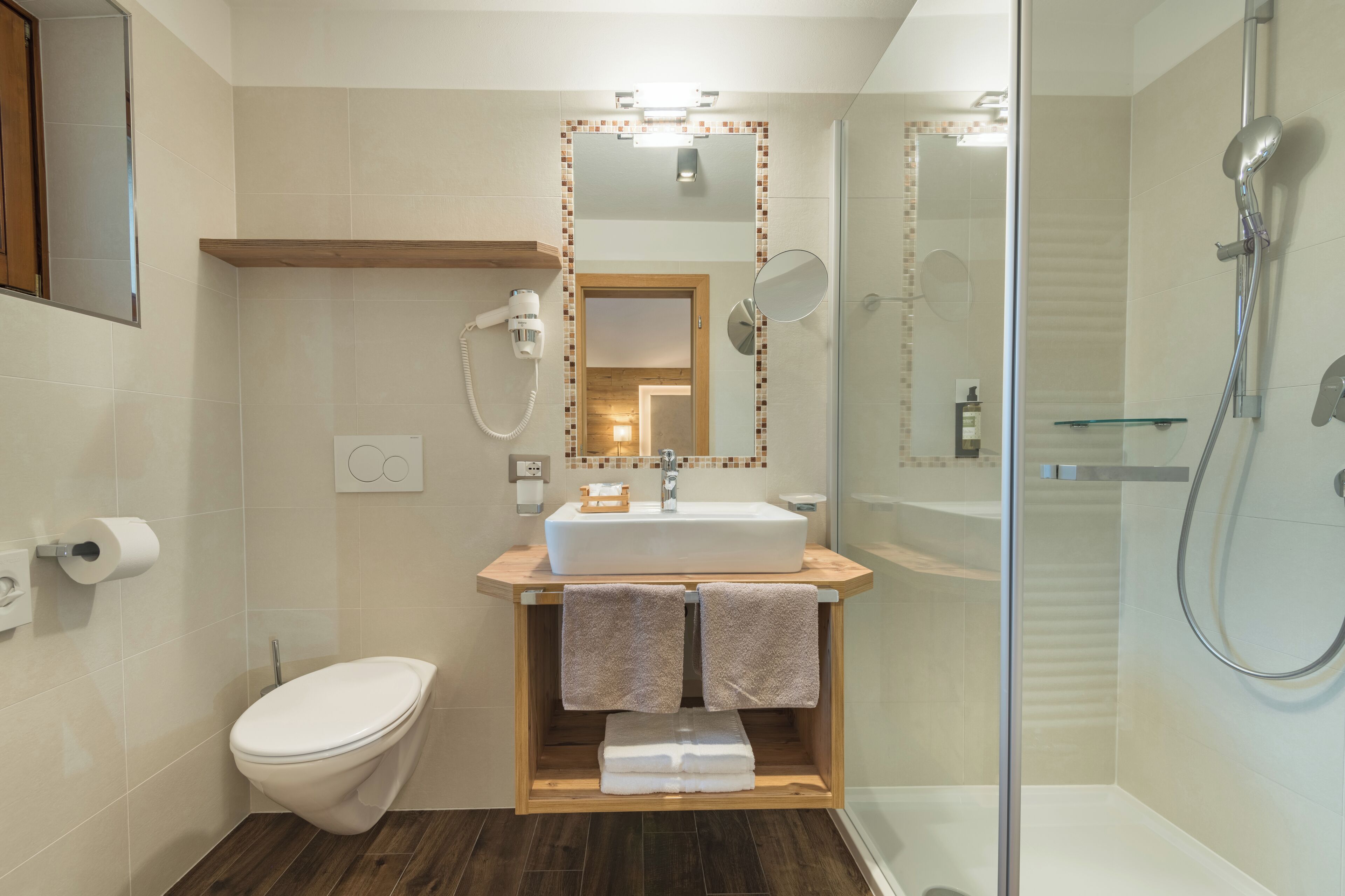 A modern bathroom with a toilet, sink, and shower.