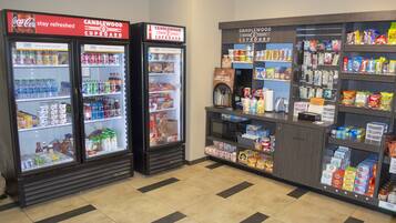 A convenience store with refrigerated beverage coolers, snack aisles, and a coffee machine.
