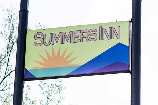 A sign for Summers Inn with a sun and mountain graphic.