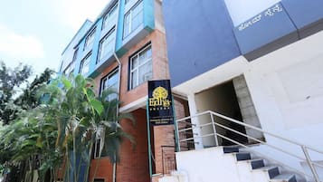 A building with a sign for 'Edha Suites' and a staircase leading to an entrance.
