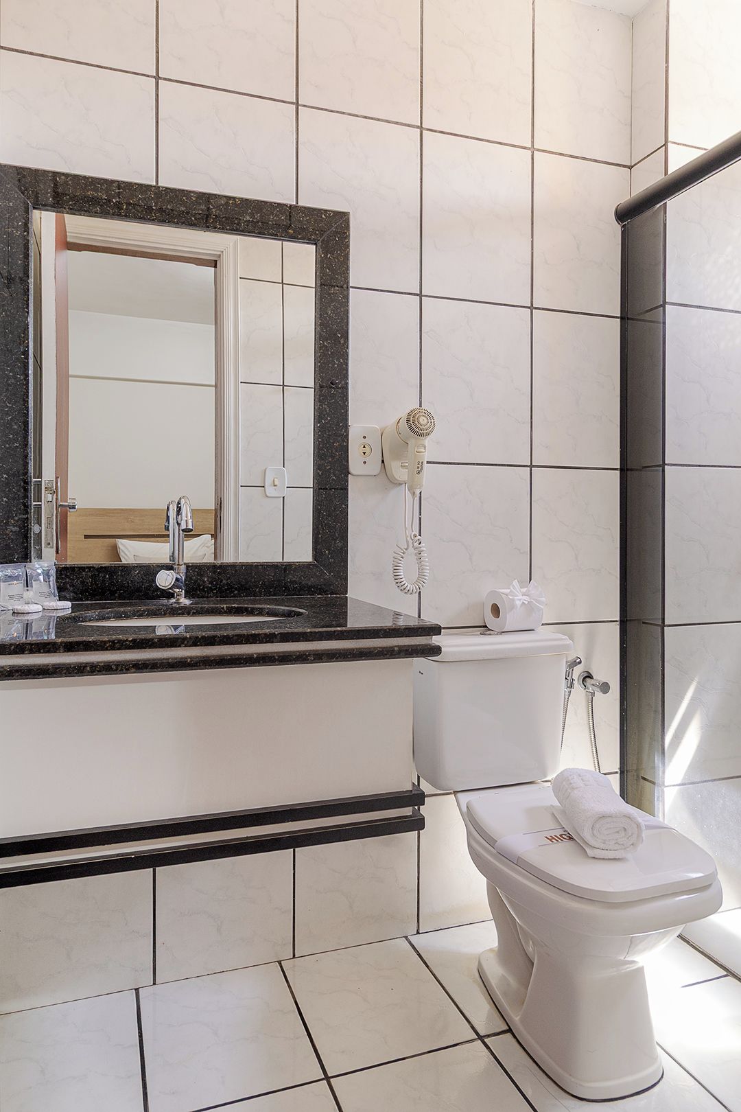 Une salle de bain avec des toilettes, un lavabo et une douche.