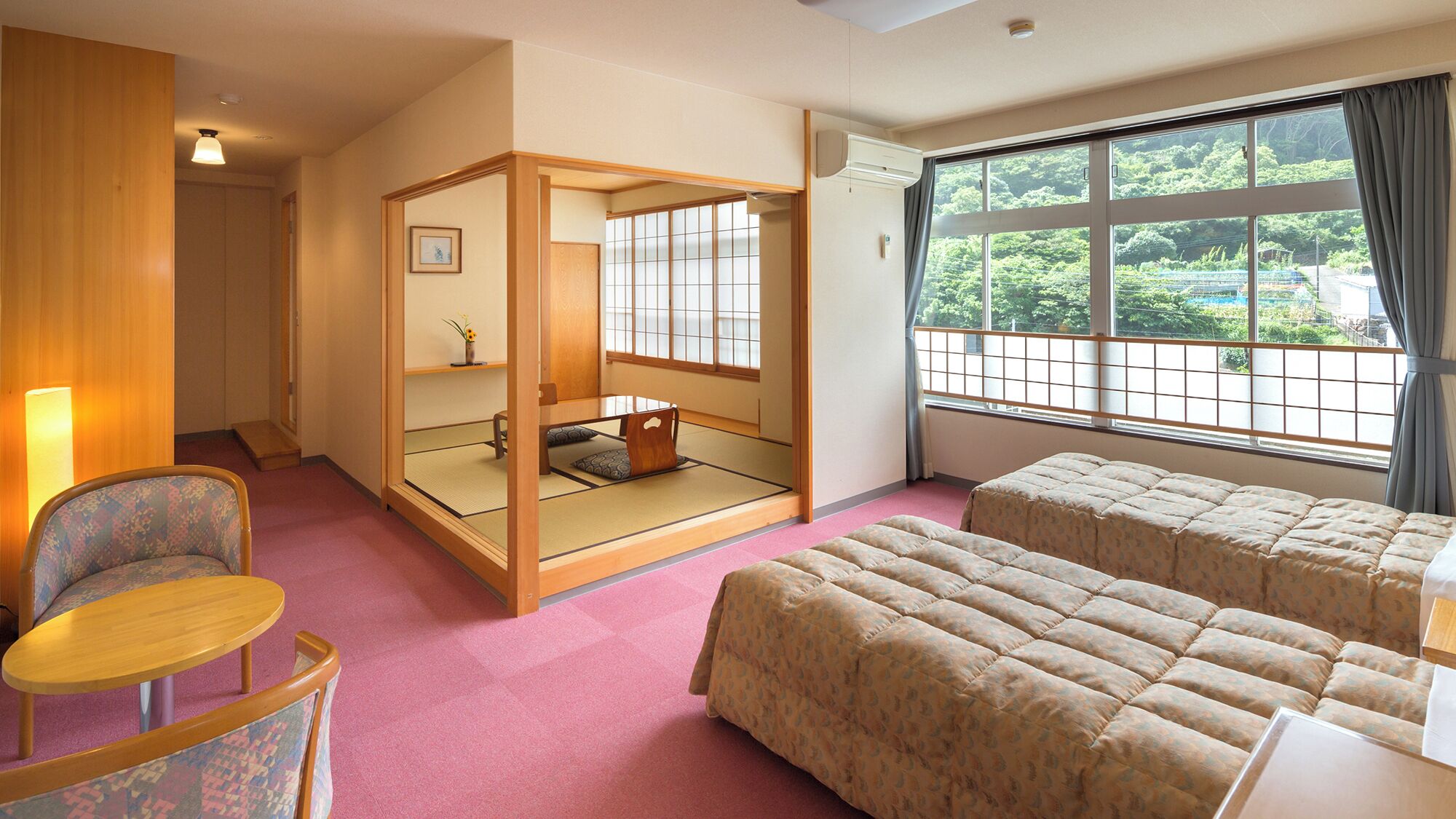 Una habitación tradicional japonesa con suelo de tatami, un biombó shoji y camas futón.