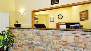 A reception area with a stone counter, a clock, and a framed picture on the wall. - Ocean Villas Beach Resort (Myrtle Beach)