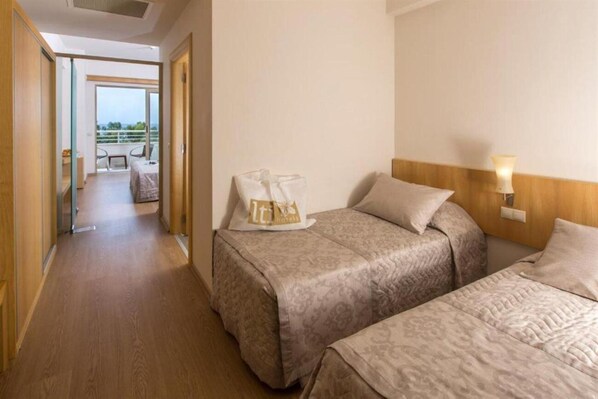 A hotel room with two beds, a balcony with a view, and a small seating area. - Lycus Beach Hotel (Alanya)
