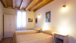 A bedroom with two beds, a wardrobe, and a nightstand. - Ca' Dei Fuseri (Venice)