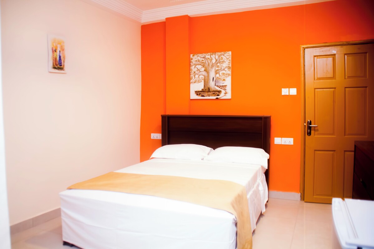 Habitació d'hotel amb un llit, una porta i un quadre penjat a la paret.