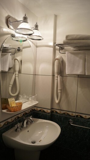 A bathroom with a sink, mirror, towel rack, and a hairdryer. - Bastion Hotel (Sinaia)