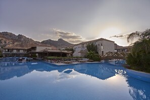 Una piscina al aire libre, sombrillas, tumbonas