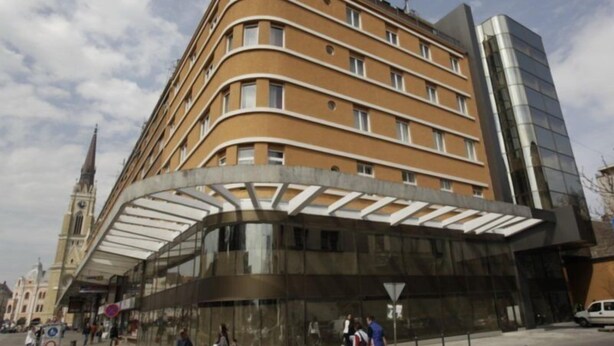 Un hotel moderno con fachada curva, ventanas amplias y acceso cubierto.