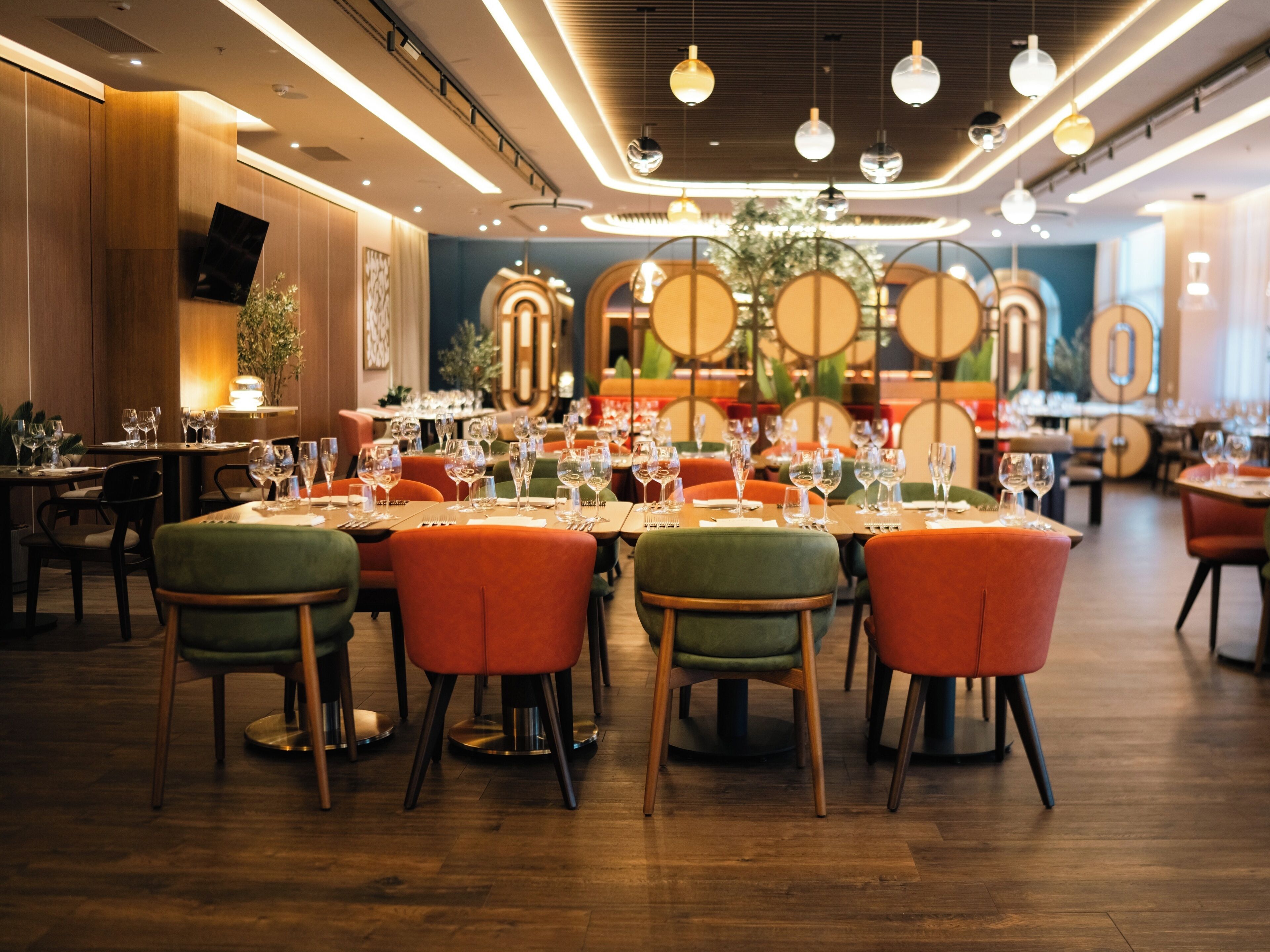 Un interior de restaurante con mesas redondas, sillas e iluminación colgante.