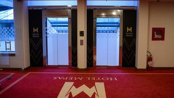 A hotel entrance with a red carpet and a large 'M' logo.