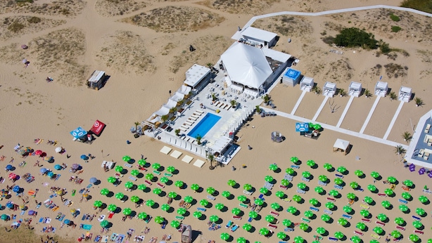 An aerial view of a resort with a large pool, multiple beach umbrellas, and a parking area. - Rainbow 1 Holiday Complex (Sunny Beach)