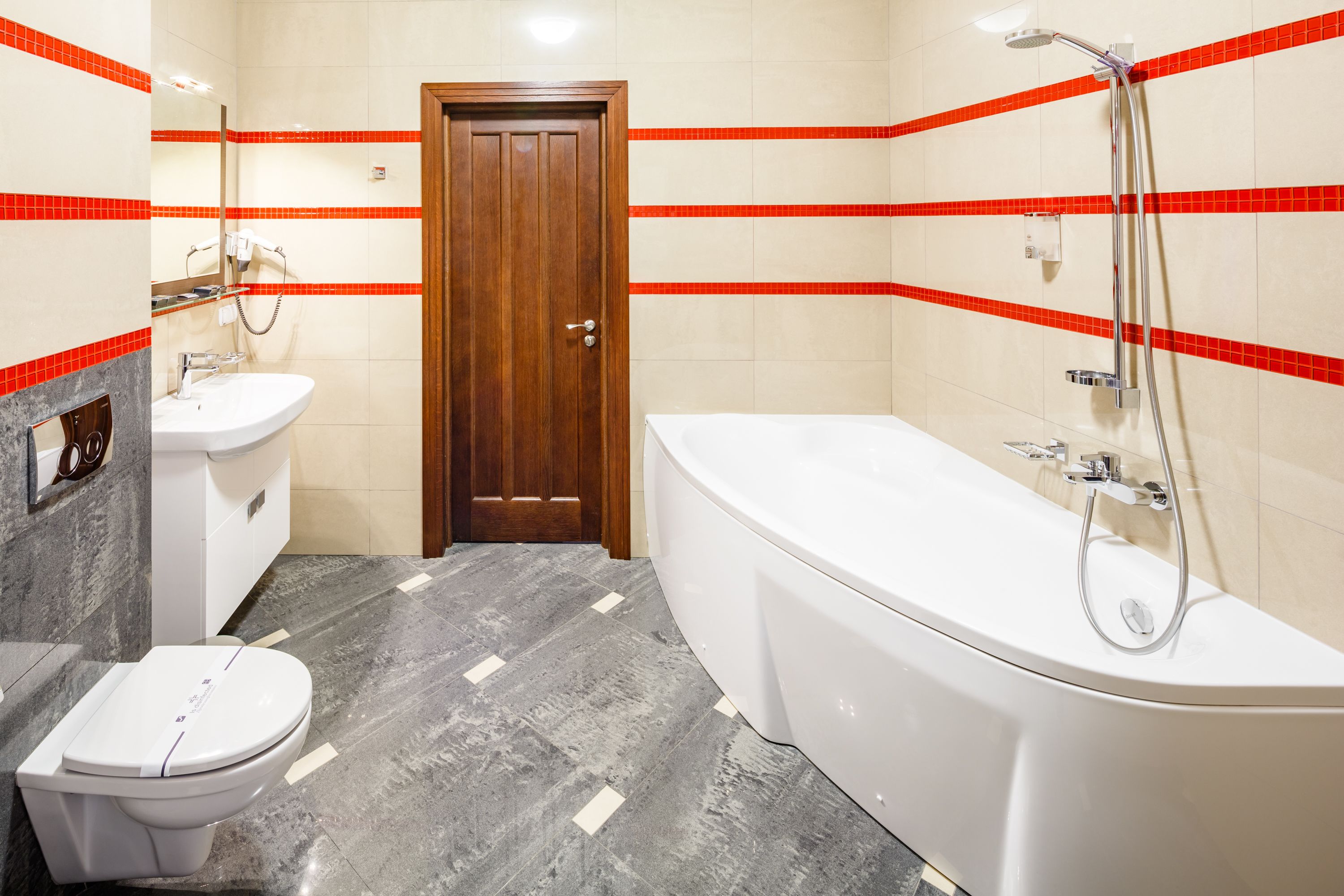 Un baño con una bañera blanca, un inodoro blanco y un lavamanos.