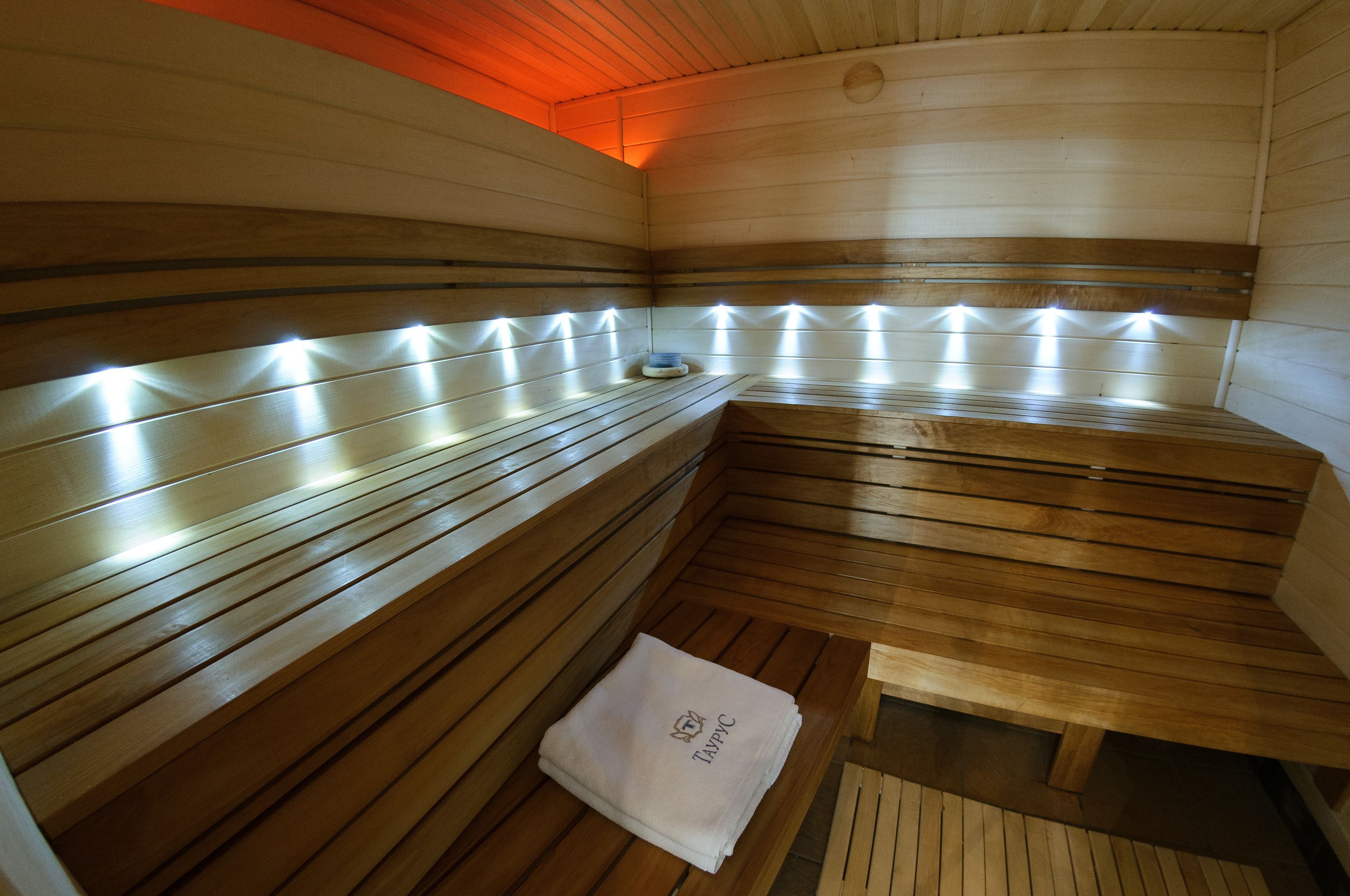 A sauna with wooden benches and a towel on the floor.