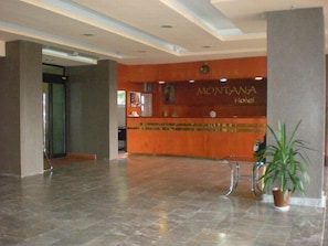 A reception area with a reception desk, a plant, and a sign that reads 'MONTANA Hotel.' - Montana Palas Hotel (Krusevo)