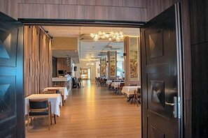 An interior view of a restaurant with tables and chairs arranged for dining. - Montana Palas Hotel (Krusevo)