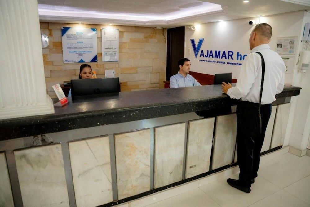 A reception desk with a marble counter and a sign for 'VAJAMAR hotel'.