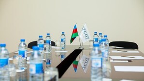 A conference table with water bottles and flags. - Azcot (Baku)