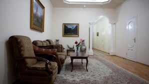 A living room with a sofa set, a coffee table, and two paintings on the wall. - Azcot (Baku)