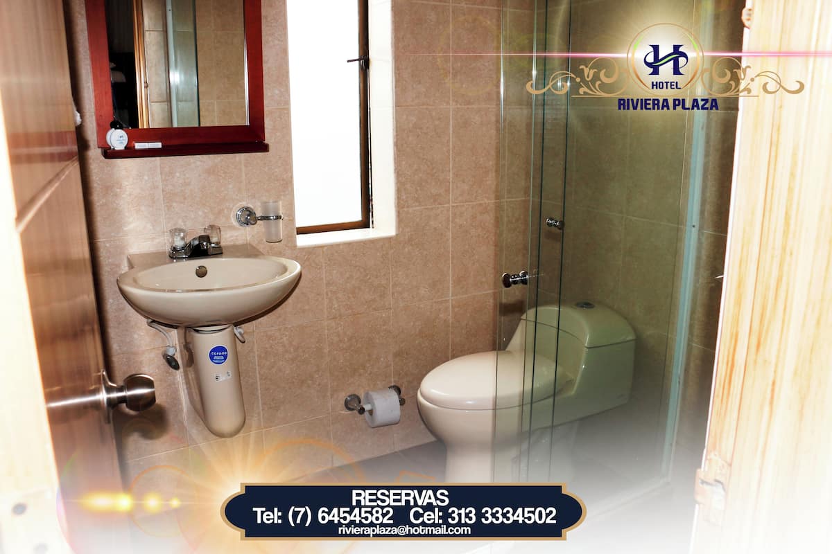 A bathroom with a sink, toilet, and glass shower enclosure.