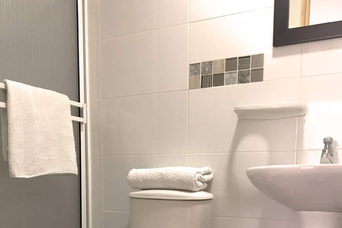 A bathroom with a toilet, sink, and a towel rack.