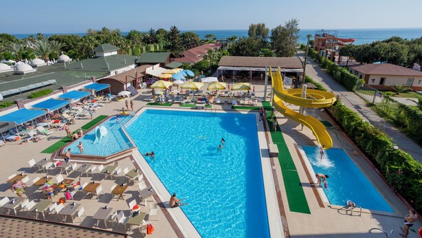 A large swimming pool with a water slide, lounge chairs, and umbrellas. - Clover Magic Park Beach Alanya (Alanya)