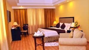 A hotel room with a bed, a sofa, a desk, and a chair. - Gokulam Park Sabari OMR Hotel (Tirupporur)