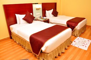 A hotel room with two beds, a nightstand, and a small table with a lamp. - Gokulam Park Sabari OMR Hotel (Tirupporur)
