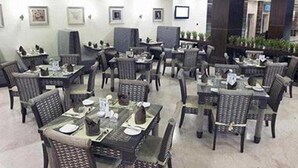 A restaurant with multiple tables and chairs, some with menus and glasses. - Gokulam Park Sabari OMR Hotel (Tirupporur)