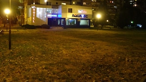 Un hotel con un cartel grande que dice 'HOTEL' y un cartel que indica 'AQUATEC', señalando una piscina o instalaciones acuáticas.