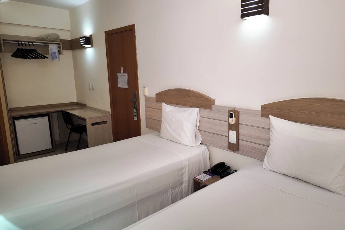 Una habitación de hotel con dos camas, un escritorio y una silla.
