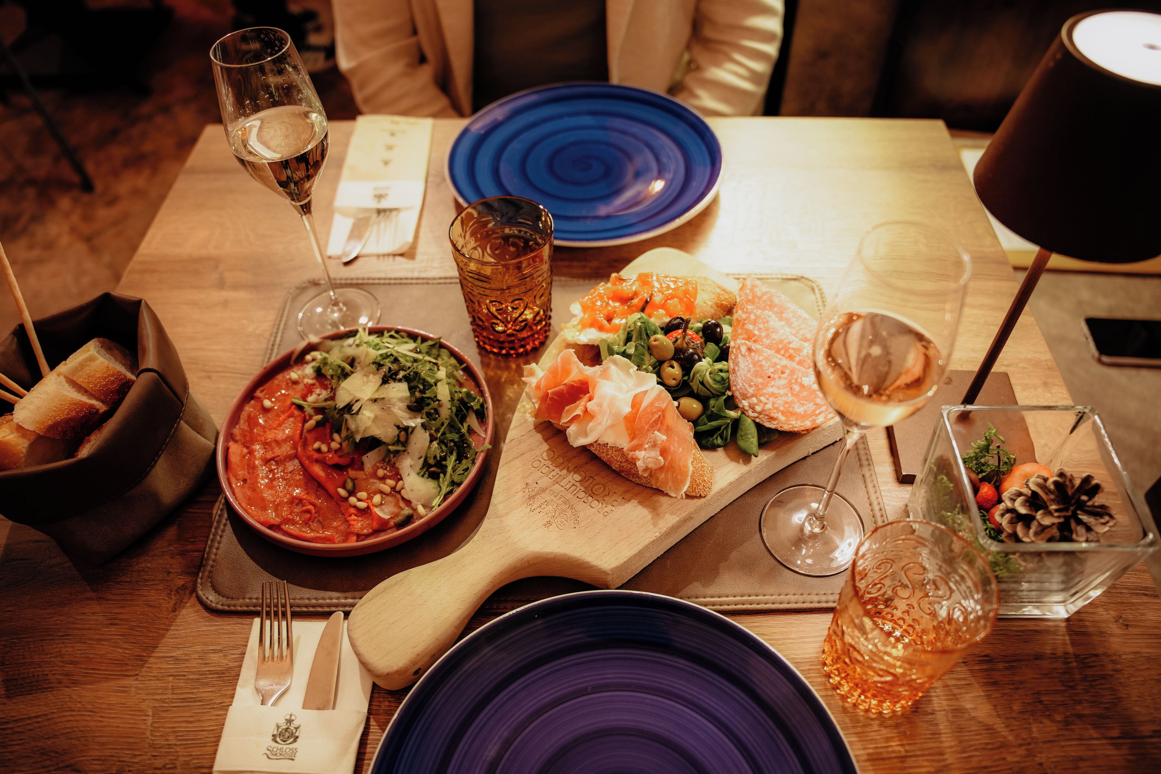 Una mesa de comedor con una variedad de platos, vasos y cubiertos.