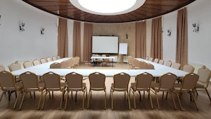 A conference room with a long table, chairs, a whiteboard, and a projector screen. - Rina Vista (POIANA BRASOV)