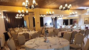 A banquet hall with round tables, chairs, and chandeliers. - Rina Vista (POIANA BRASOV)