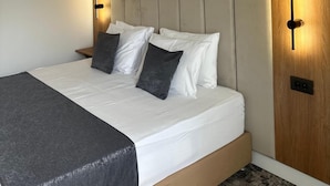 A modern bedroom with a bed, headboard, bedside lamps, and a wooden accent wall. - Rina Vista (POIANA BRASOV)