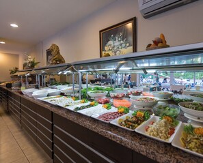 Ein Buffet mit verschiedenen Speisen und einer Löwenstatue an der Wand.