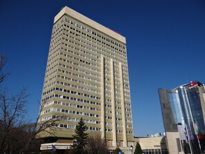 Ein hohes, mehrgeschossiges Gebäude mit einer beige farbenen Fassade und zahlreichen Fenstern.