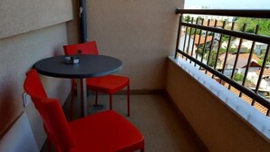 A small balcony with a round table and two red chairs. - Apart Hotel Kalonis Skopje (Skopje)