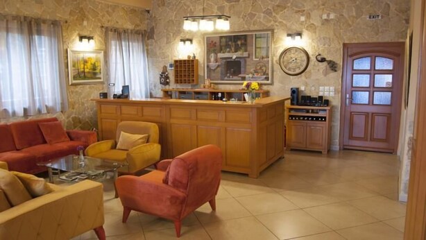 A cozy living room with a fireplace, a bar area, and a dining table. - Hotel Portal (Skopje)