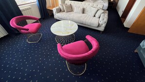 A modern living room with a sofa, two pink armchairs, and a round coffee table. - Saint George Nessebar (Nessebar)
