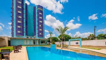 Relax by the rectangular pool surrounded by a deck with comfortable seating and lush greenery.