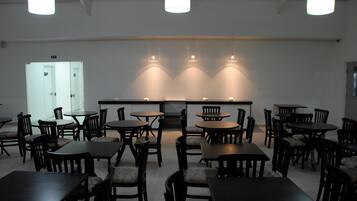 A spacious room with multiple tables and chairs arranged in a U-shape around a central counter.